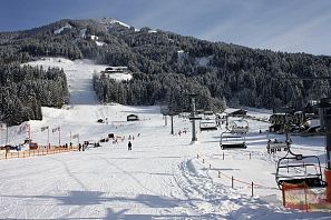 Łąka treningowa SkiWelt z dziećmi w Westendorf z widokiem na góry