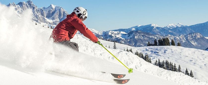 piste-kaiserwetter-skiwelt-wilder-kaiser-brixental-roter-skianzug-gelbe-stoecke-2