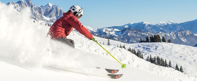 piste-kaiserwetter-skiwelt-wilder-kaiser-brixental-roter-skianzug-gelbe-stoecke-57