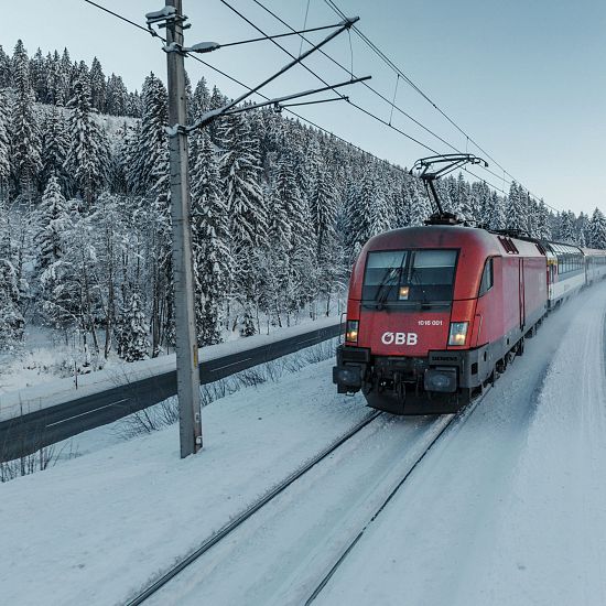 roter-zug-der-oebb-faehrt-im-winter-durch-schnee-auf-den-schienen-1-10