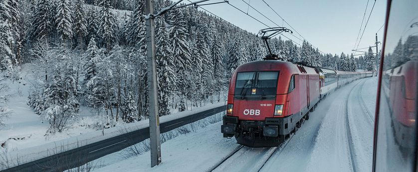 roter-zug-der-oebb-faehrt-im-winter-durch-schnee-auf-den-schienen-1-2