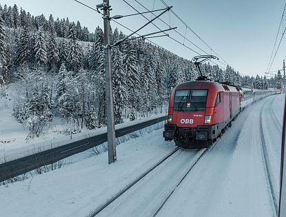 roter-zug-der-oebb-faehrt-im-winter-durch-schnee-auf-den-schienen-1-4