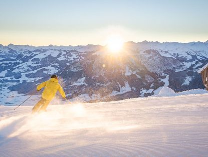 skifahren-bei-sonnenaufgang-bergspitzen-sonnenstrahlen-morgenrot-early-bird-auf-piste-skiwelt-15