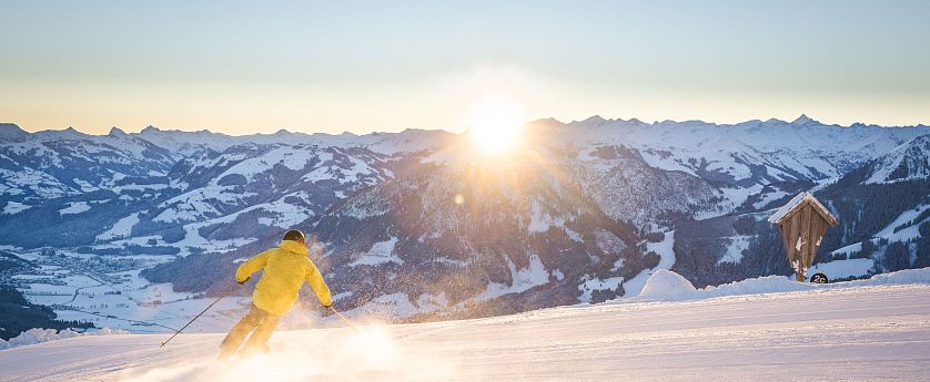 skifahren-bei-sonnenaufgang-bergspitzen-sonnenstrahlen-morgenrot-early-bird-auf-piste-skiwelt-2