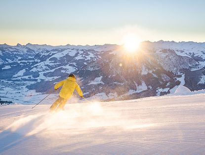 skifahren-bei-sonnenaufgang-bergspitzen-sonnenstrahlen-morgenrot-early-bird-auf-piste-skiwelt-4